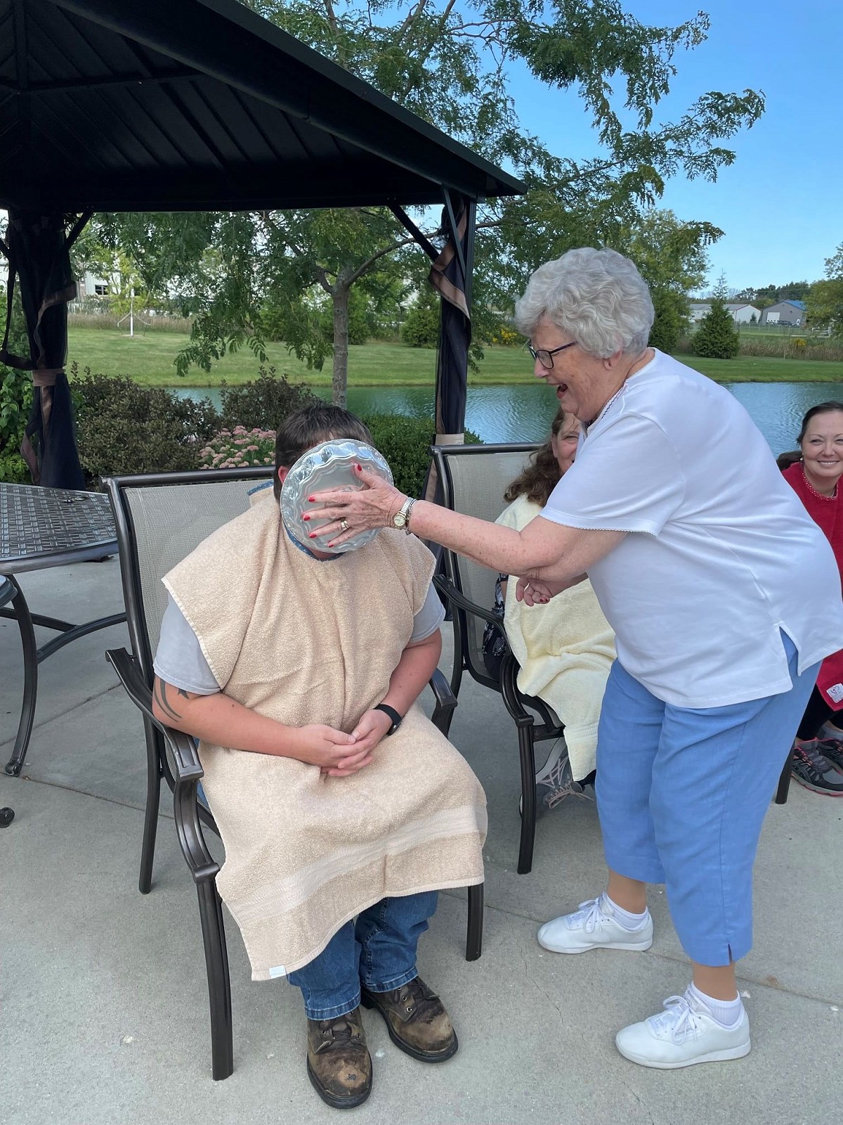 Pine Haven resident putting a pie on someone else's face for a fundraiser