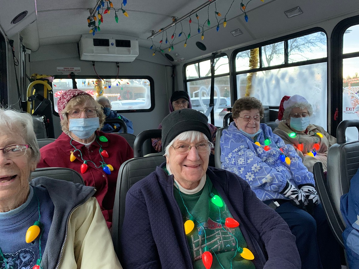 Pine Haven residents riding a bus wearing light up necklaces