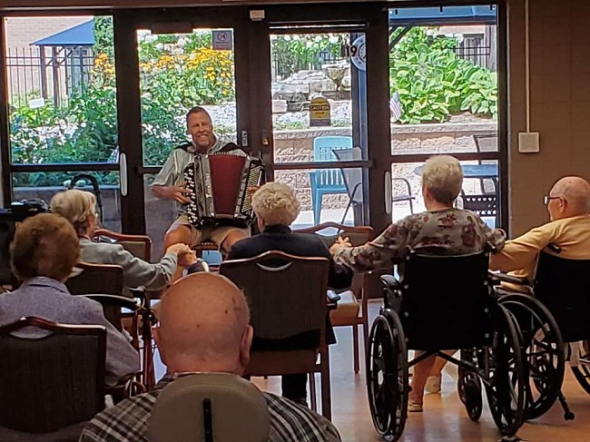 Musician playing for Pine Haven's memory care residents