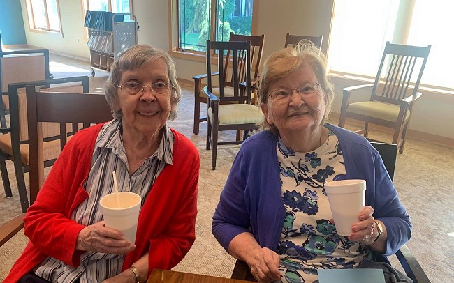 Two Pine Haven independent living residents smiling with drinks