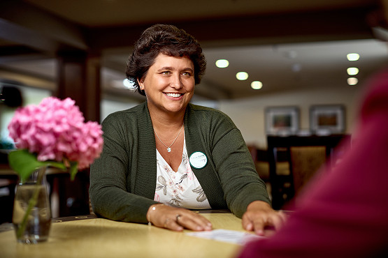 Pine Haven staff talking with resident